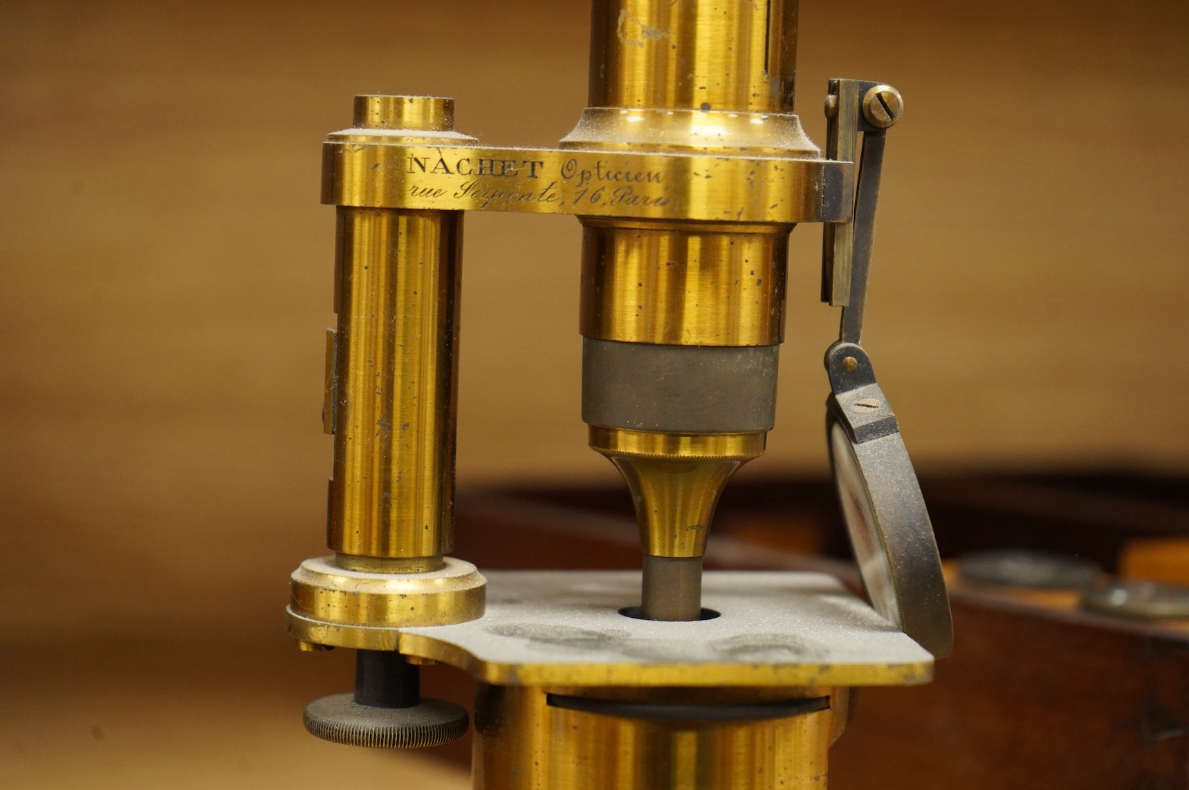 A mid 19th century French brass compound monocular microscope, by Nachet, Optician, Rue Serpente 16, Paris, with two eyepieces, three objectives and several slides, mahogany cased, instrument height 23cm